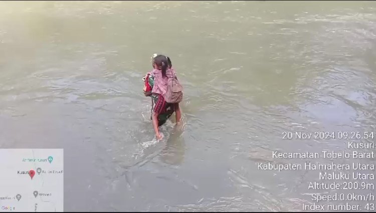 Babinsa Tobelo Barat Bantu Anak-Anak Sekolah Menyeberangi Sungai Banjir