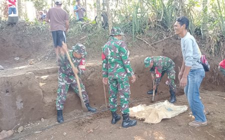 Anggota TNI bersama masyarakat melaksanakan gotong royong