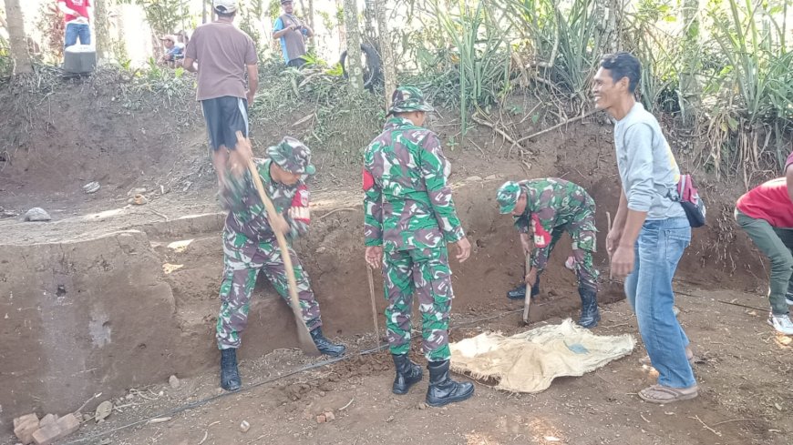 Anggota TNI bersama masyarakat melaksanakan gotong royong